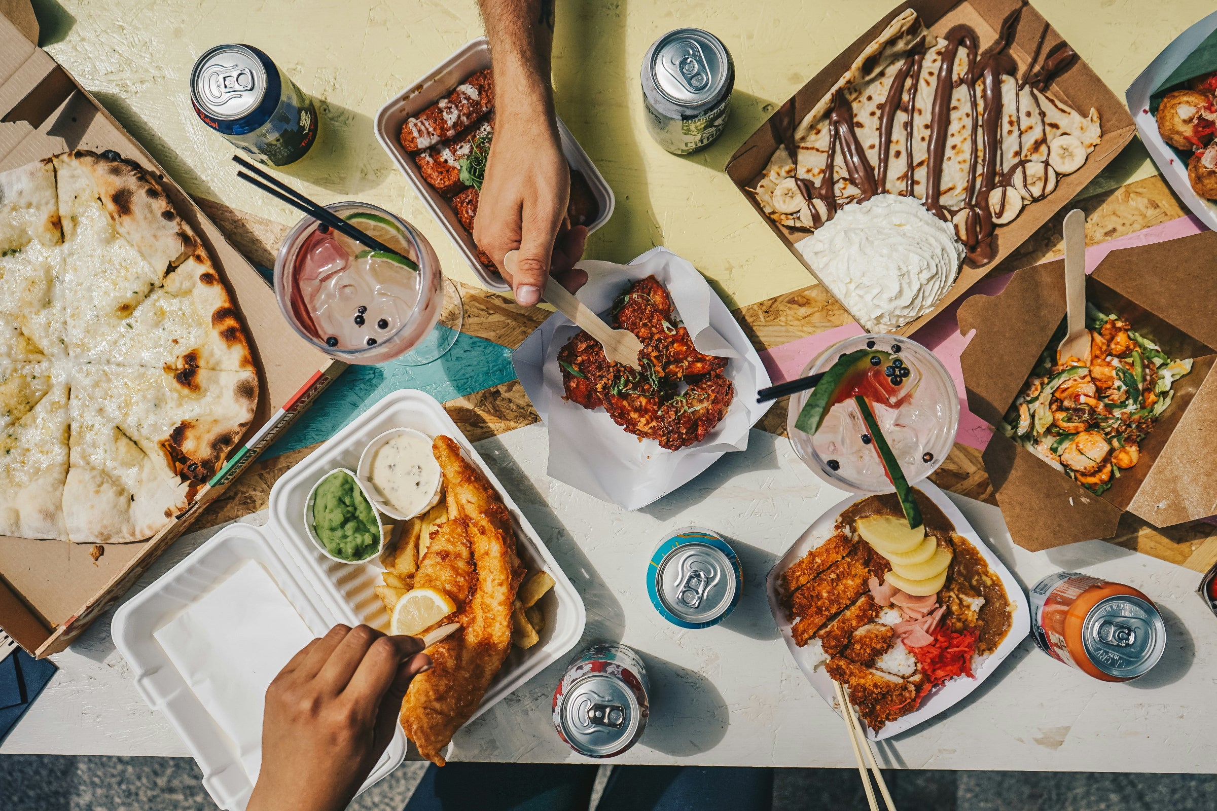 Tabletop scene with various food items and drinks on a white surface