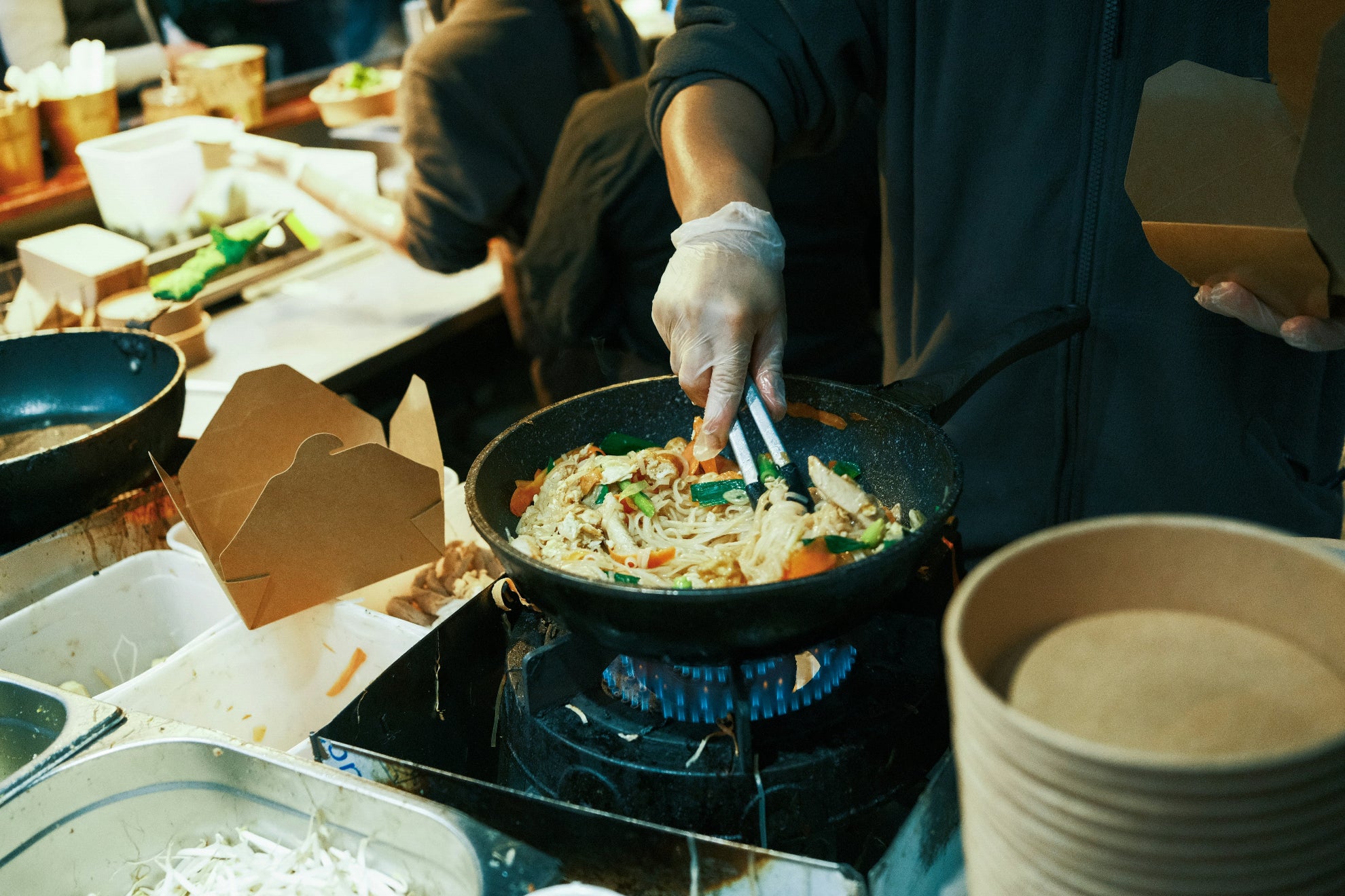 Person cooking stir-fry in a wok with various ingredients on a stove.