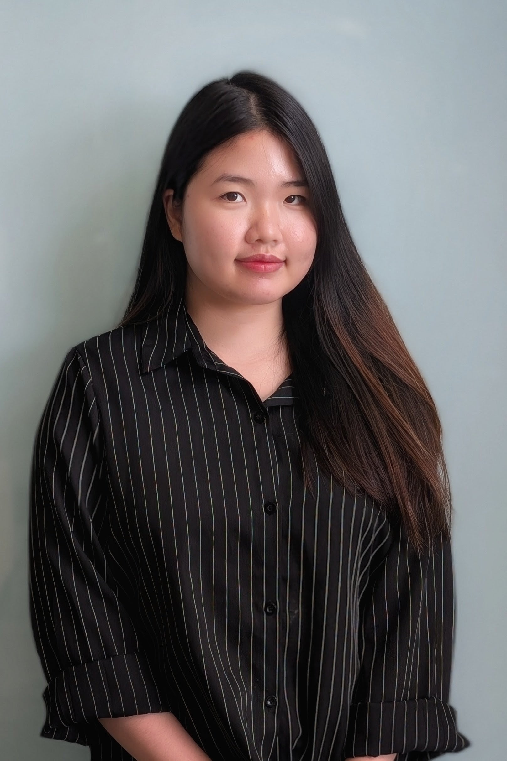 Woman wearing a black pinstripe shirt against a plain background