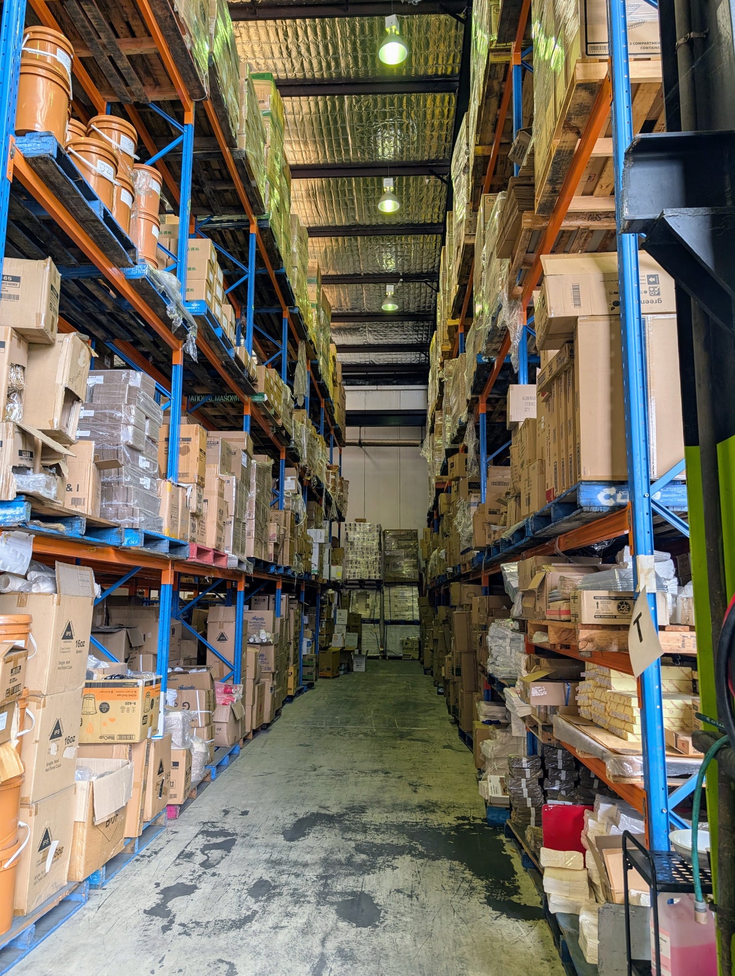 Warehouse interior with shelves stocked with boxes and barrels.
